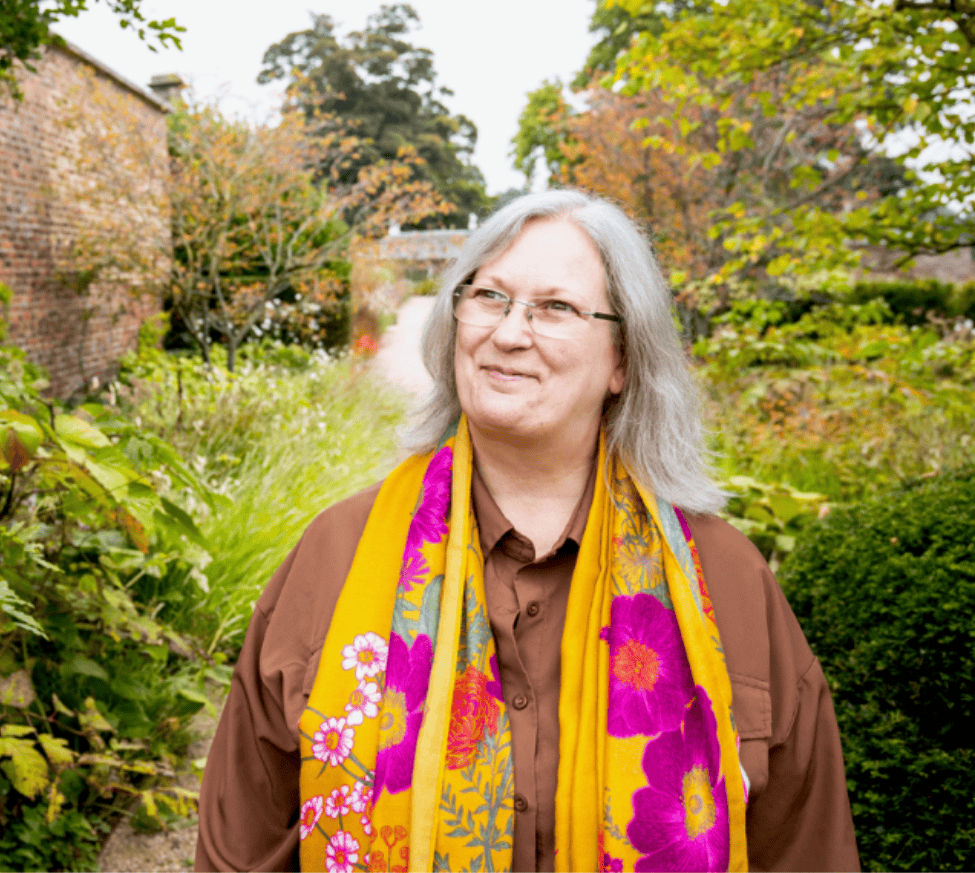 A photo of Gwen outside surrounded by greenery and trees