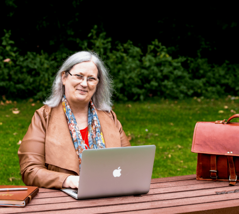 A photo of Gwen working at her laptop outside