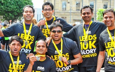 Group of runners posing for photo with their medals